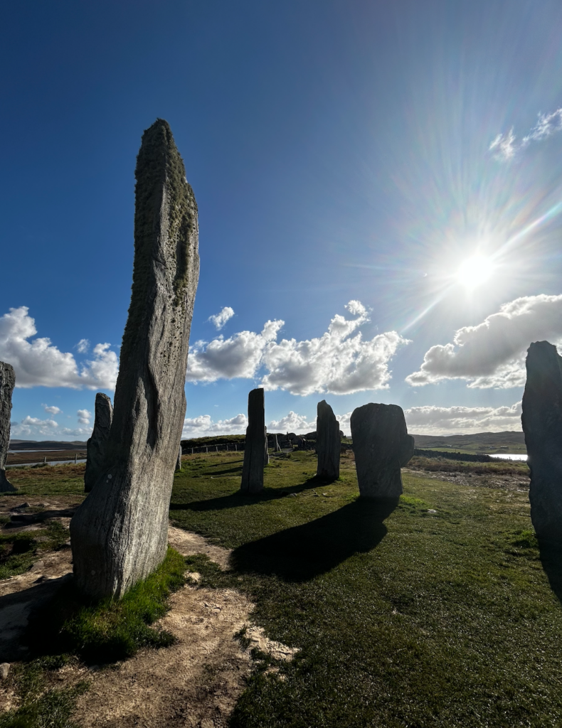 blue sky, sun shining, and a circle of ancient standing stones